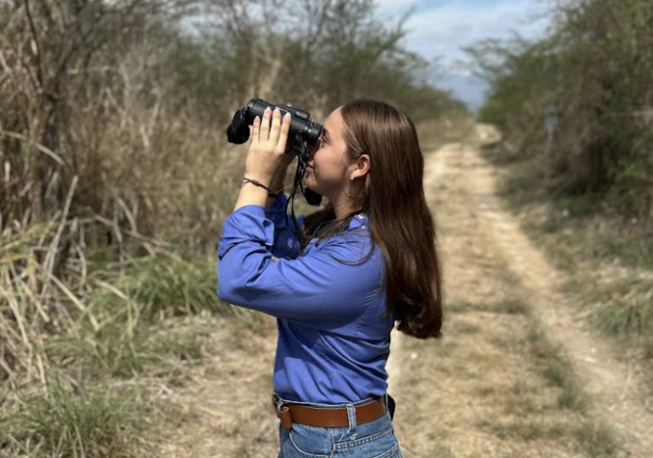 A woman uses binoculars.