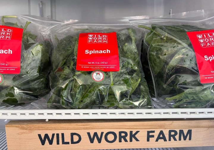 Packaged spinach and a Wild Work Farm sign
