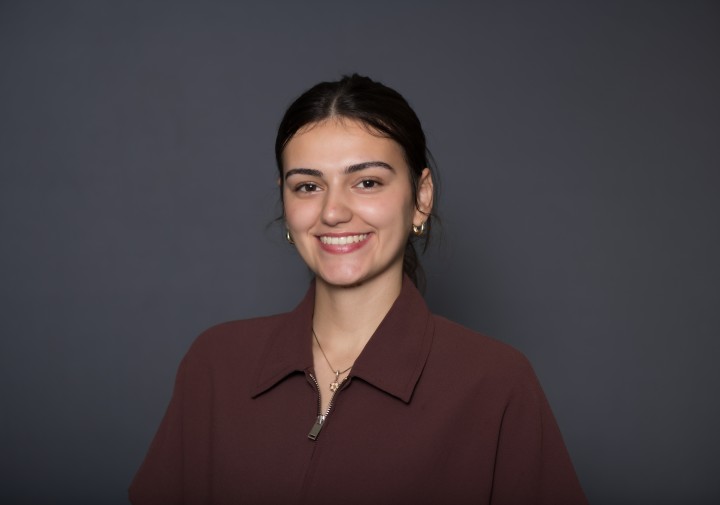 Smiling woman with blazer and black background