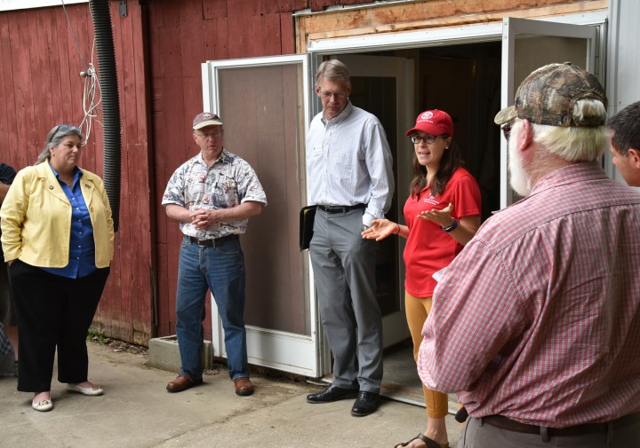 Cheryl Bilinski, standing in front of a red barn,  speaking to participants at farm to pint workshop