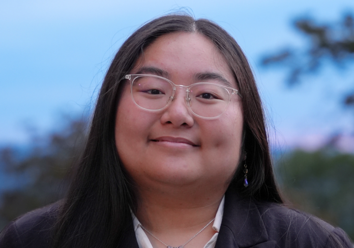 Smiling woman with glasses and black suit jacket