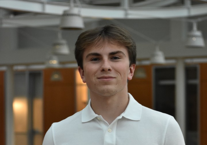 Man standing wearing white polo