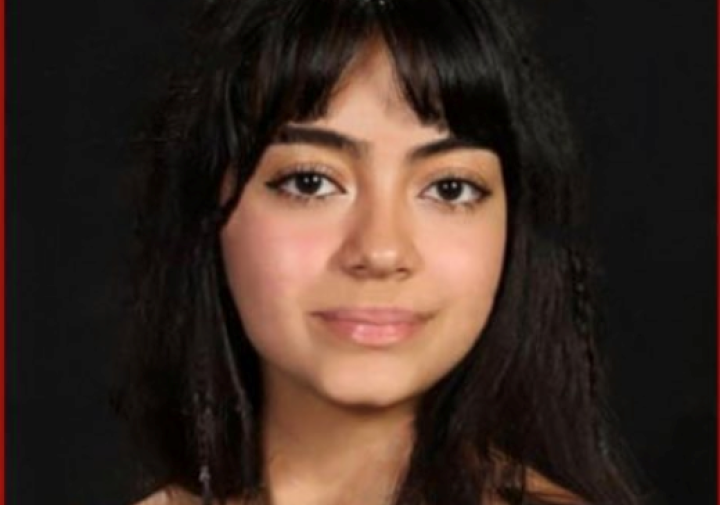 Woman with dark hair wearing off the shoulder black top