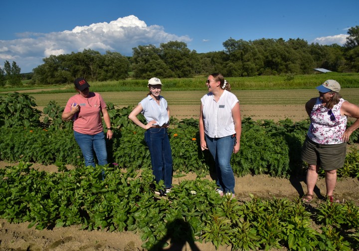 Anna  with Betsy Lamb. and staff from CCE Madison discussing inssues in a filed.