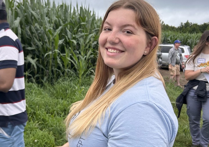 A woman smiles in a field.