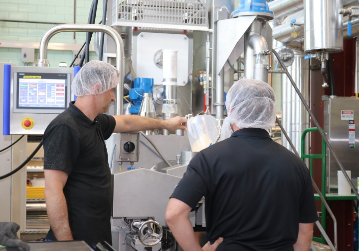 Two men working at an extruder machine