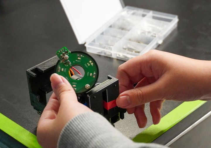 two hands are holding pieces of tech