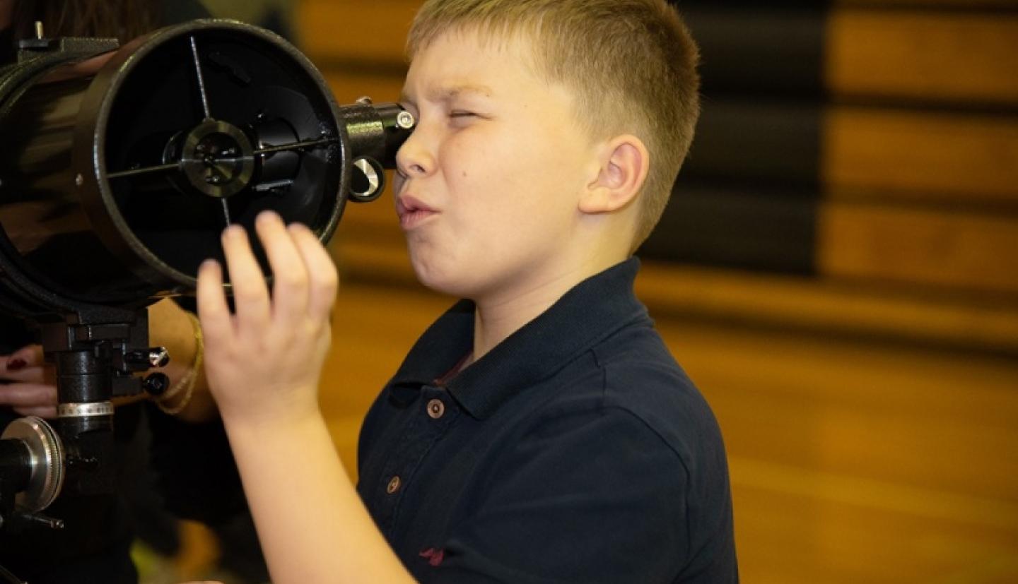 Student looking through telescope