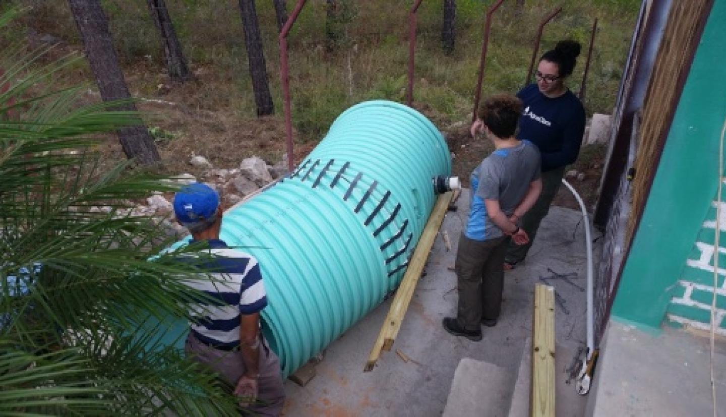 Zoe Maisel and Erica Marroquin install water purification system with Jorge Dueñas Carcamo