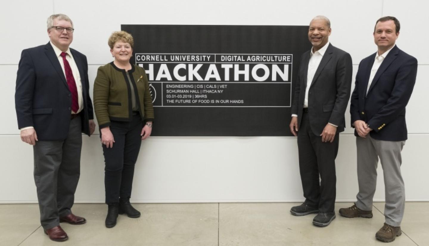 Dr. Lorin Warnick, Kathryn J. Boor, Lance R. Collins, and&nbsp;Greg Morrisett, pose near Hackathon poster