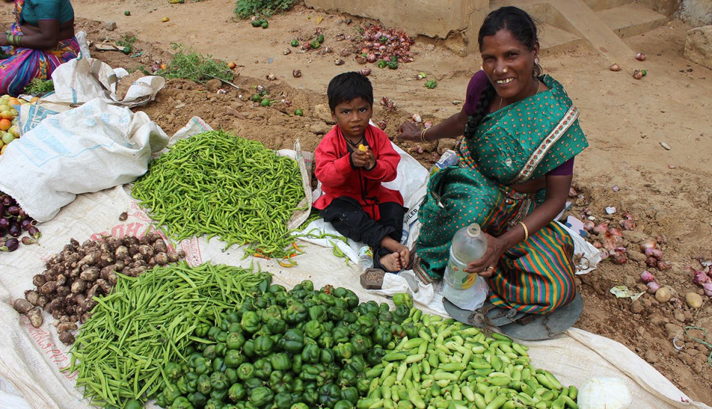 woman and child in market with vegetables