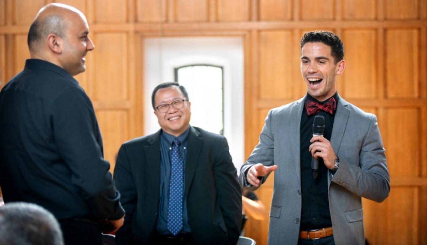 Student giving speech with Professor and High School teacher 