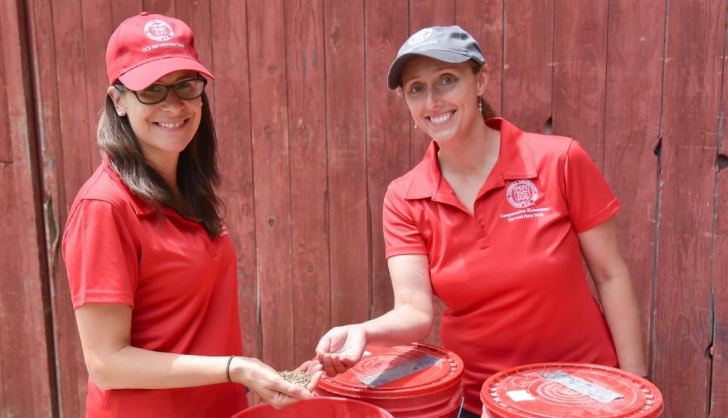 Two students with containers of barley
