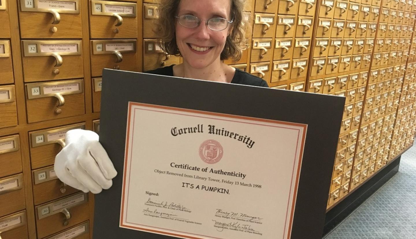 Librarian holding a certificate that says "It's a pumpkin"