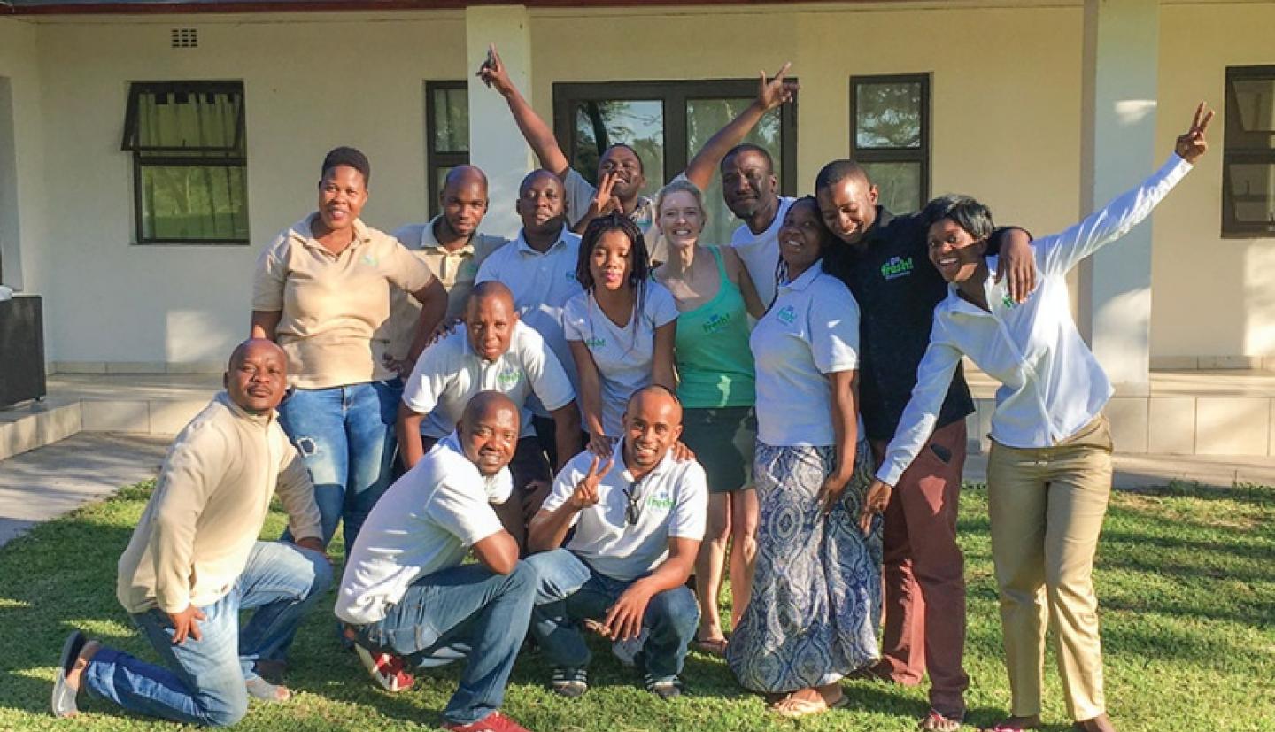 Workers pose outside building