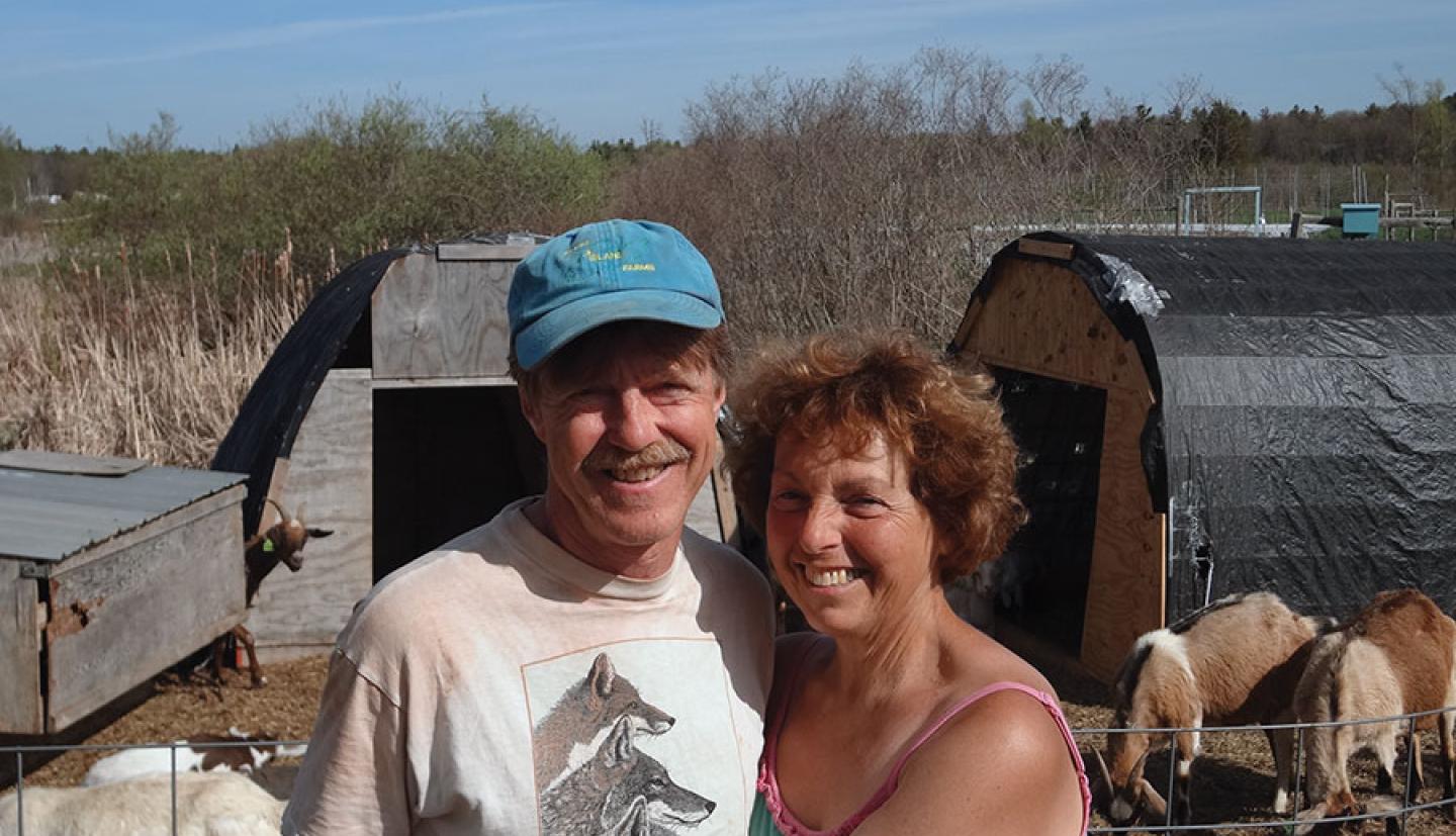 Man and woman standing with goats