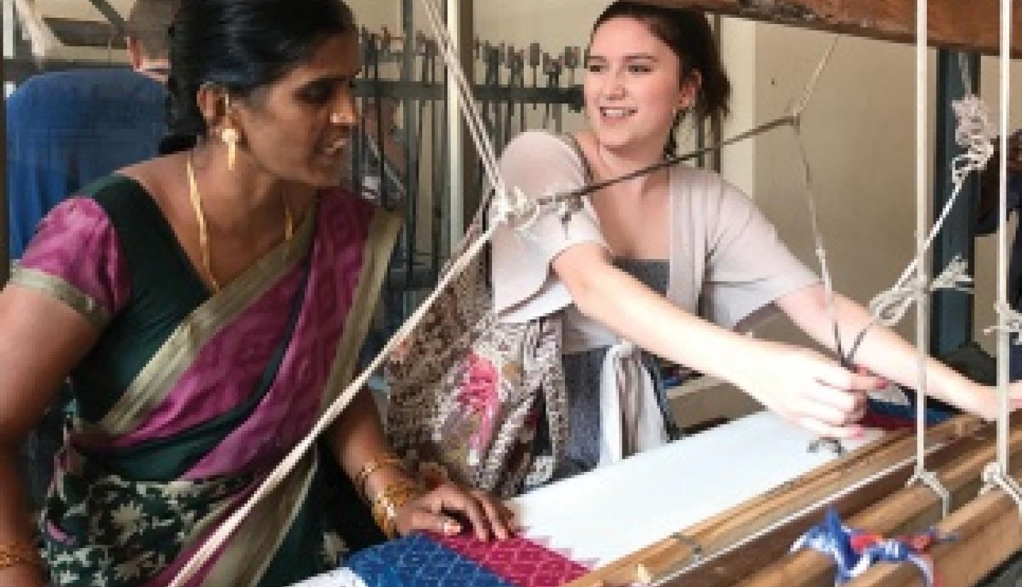 Student and weaver work on loom
