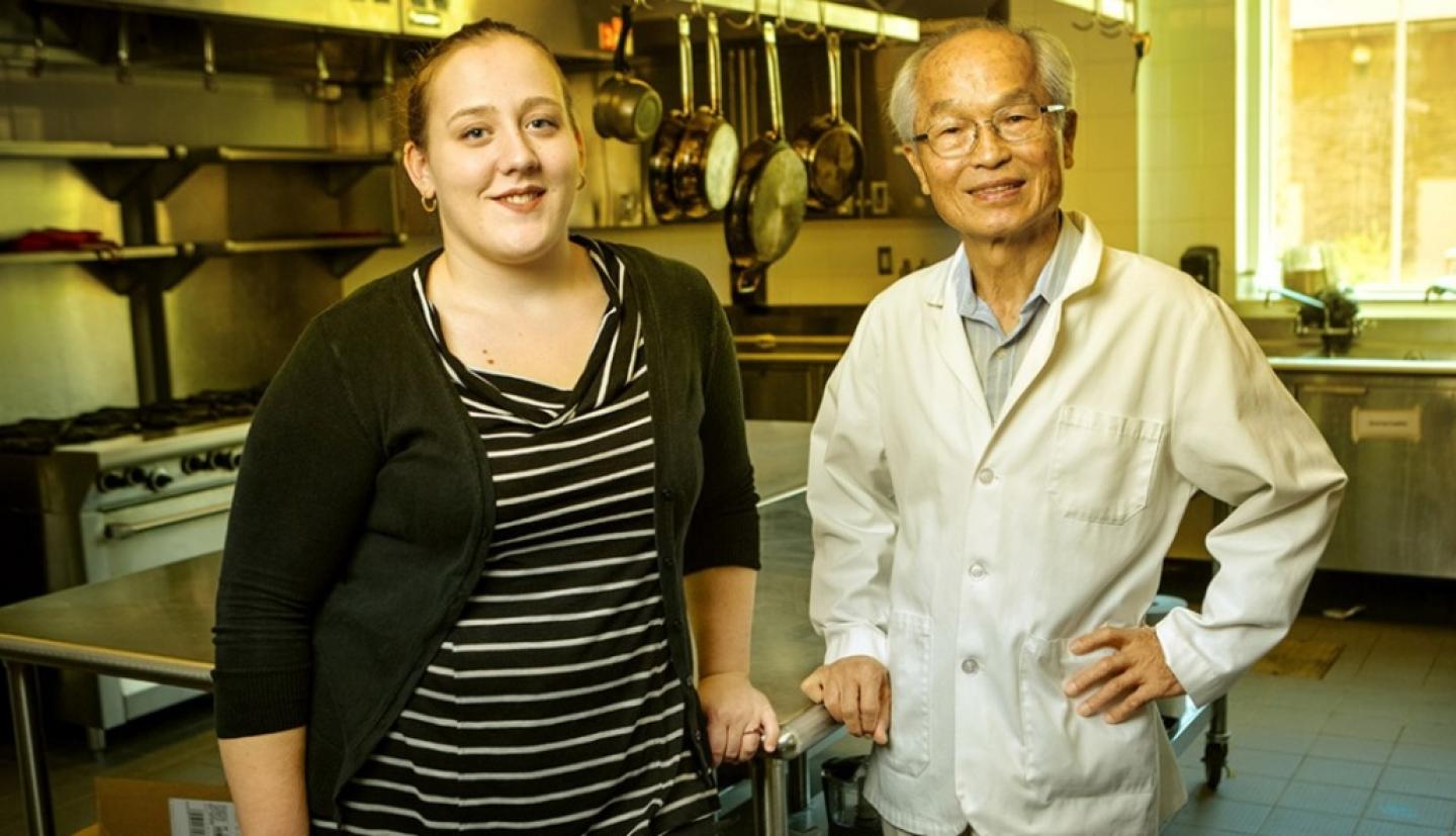 Professor and administrator stand in a kitchen