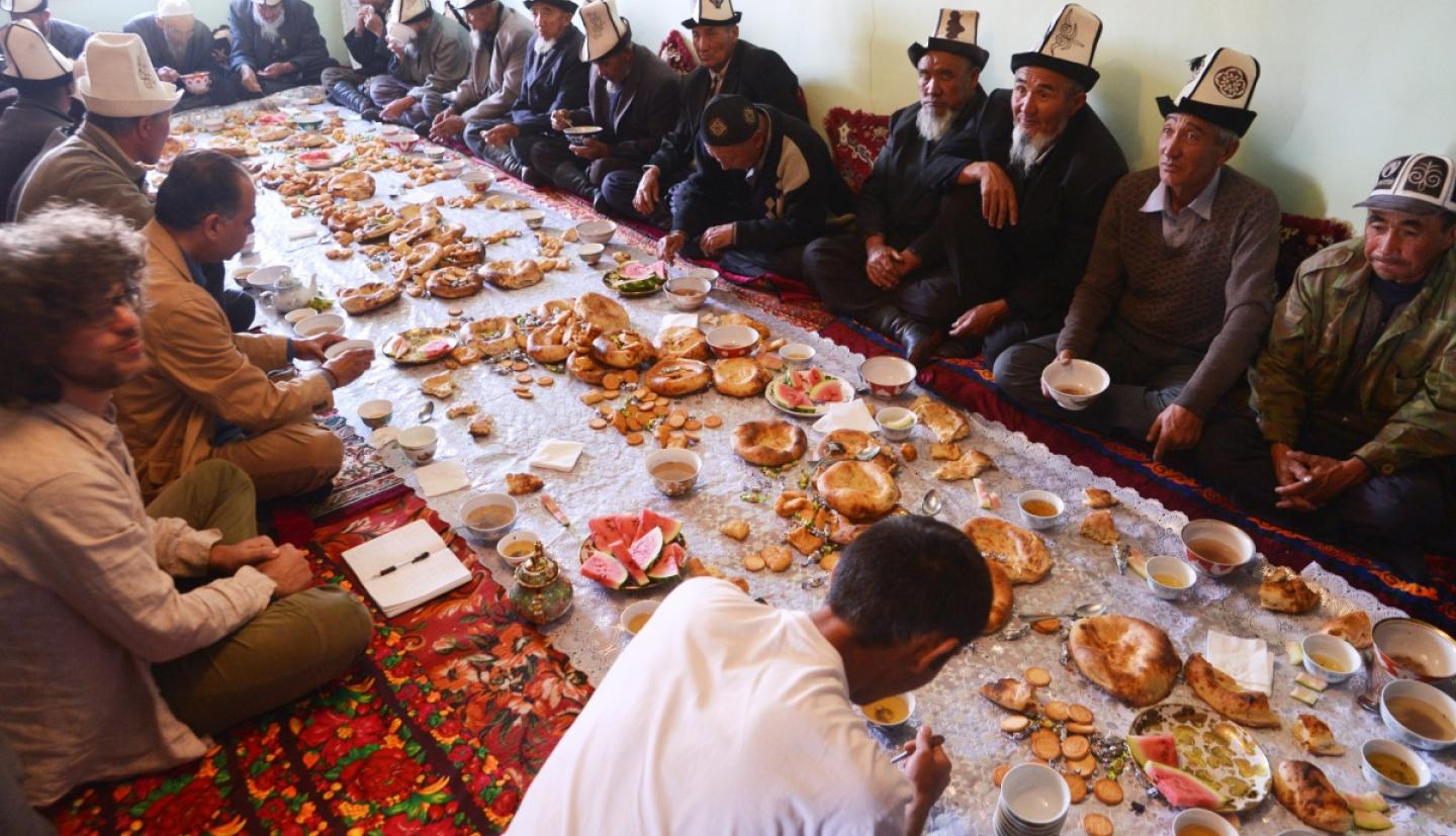 Researchers and village elders sit for a meal