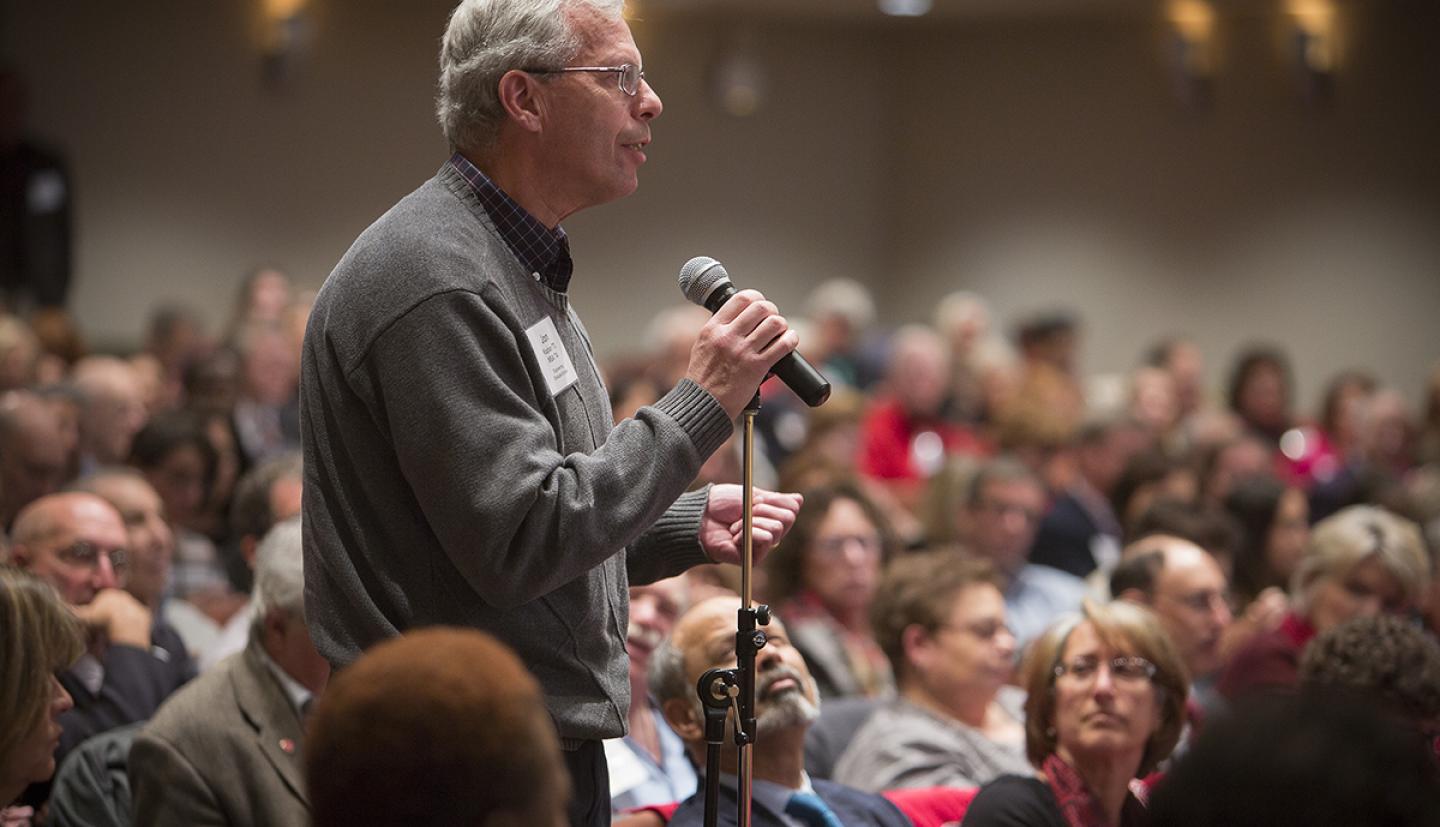 Audience member stands with a microphone