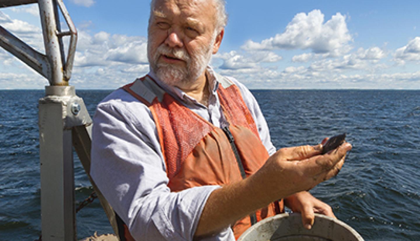 A man holds a fish on a boat