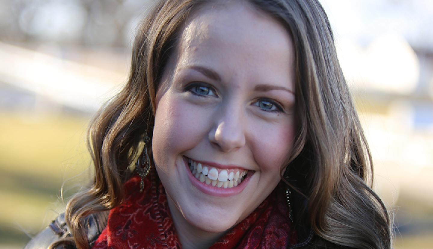 A college-aged woman smiles for a headshot