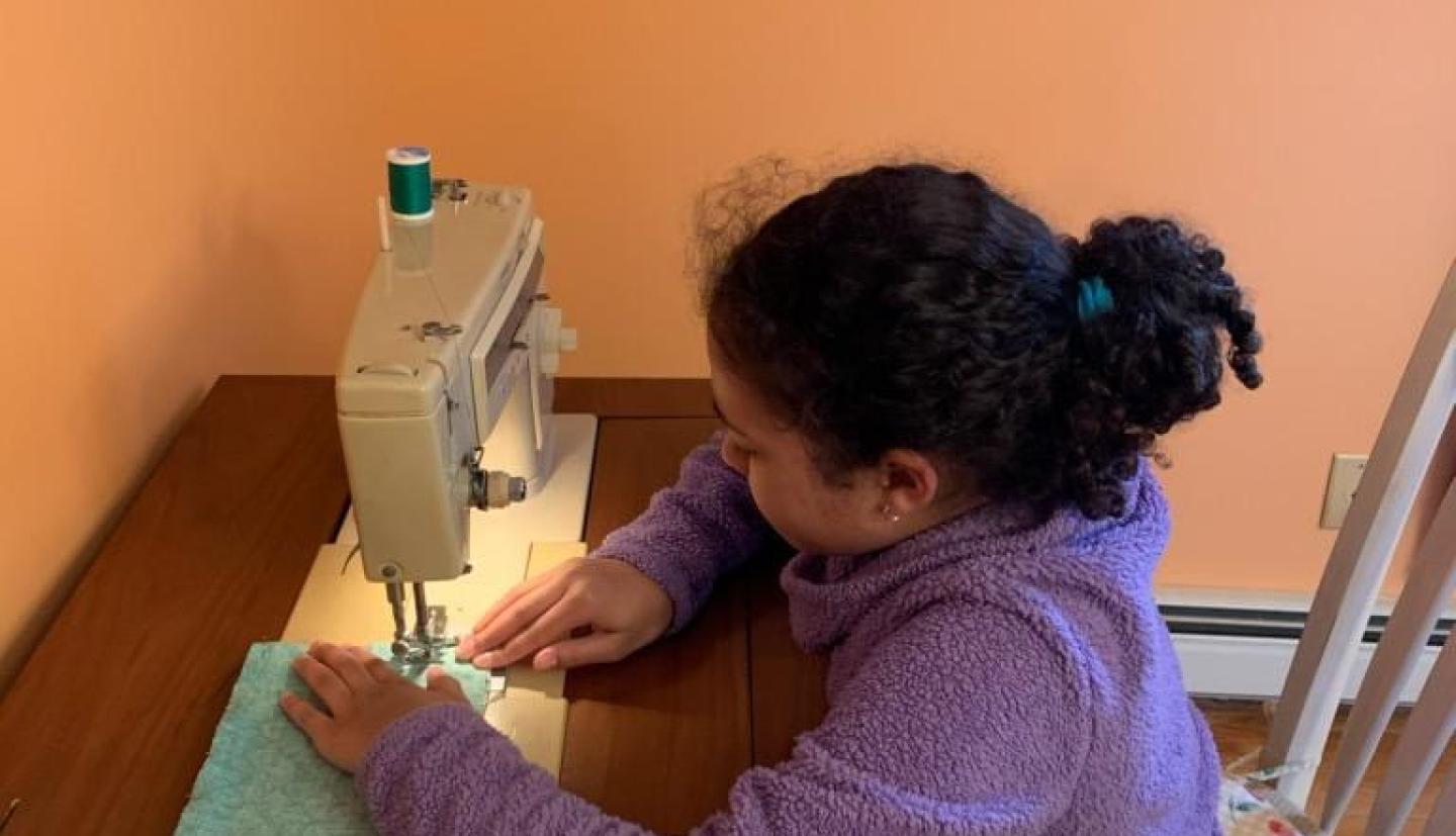 young girl at sewing machine