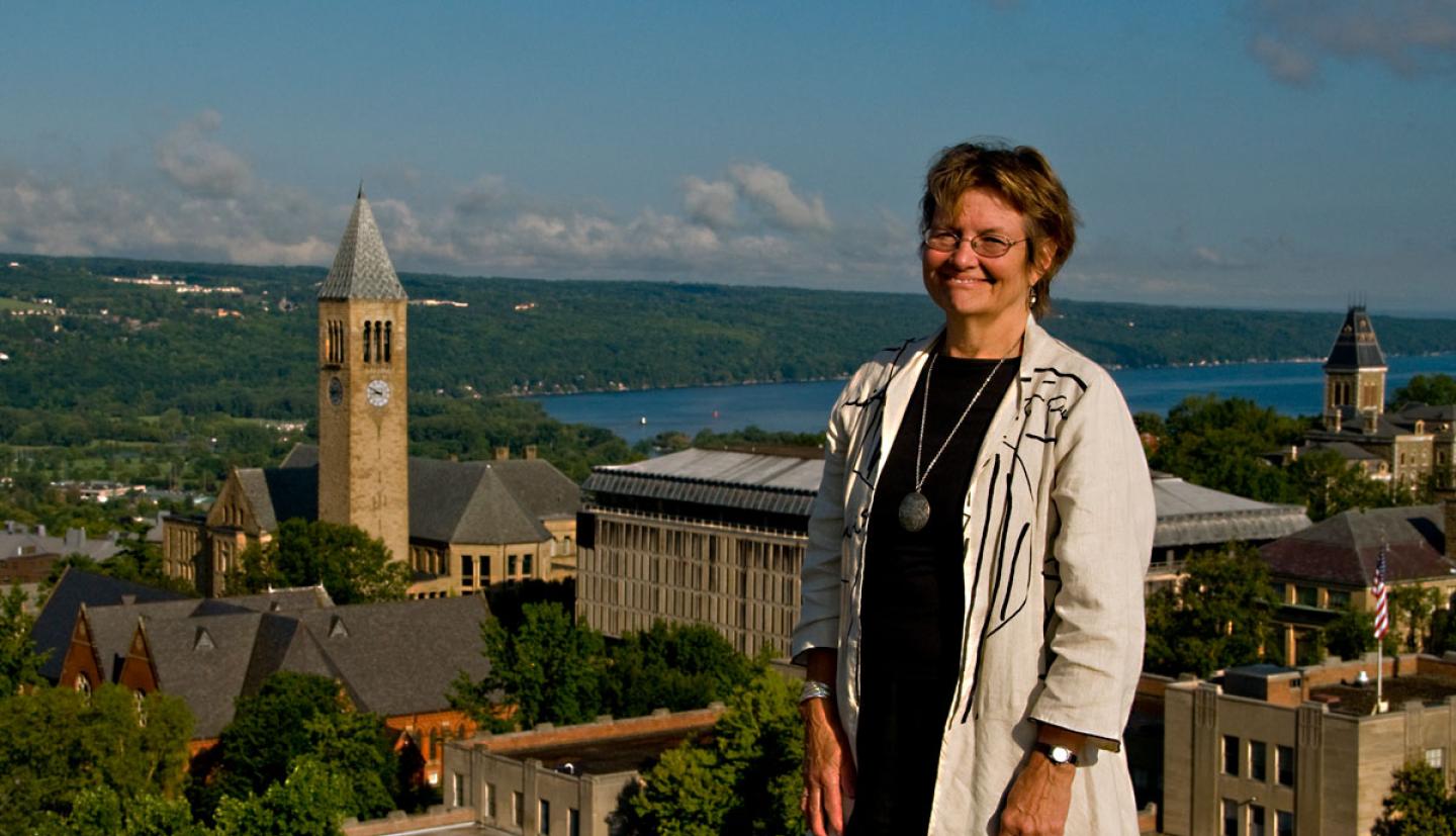 Linda McCandless stands with Cornell campus in background