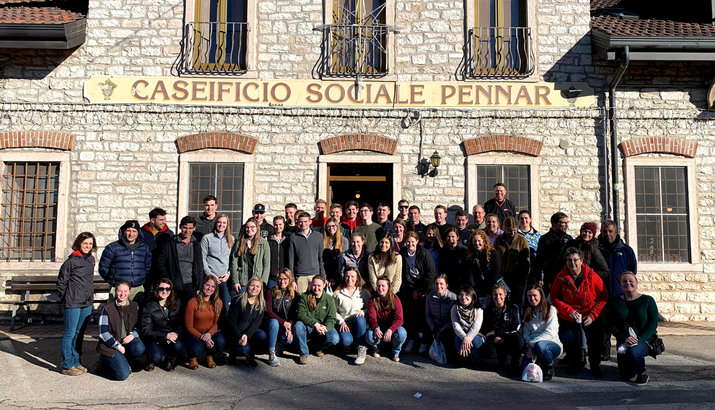 a group of people stand in front of an Italian building