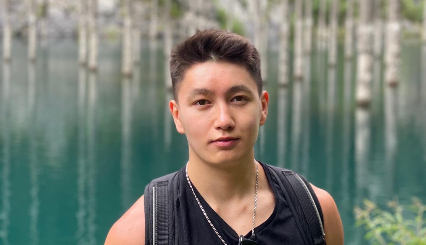 Iskender Usupbaev stands in front of lake