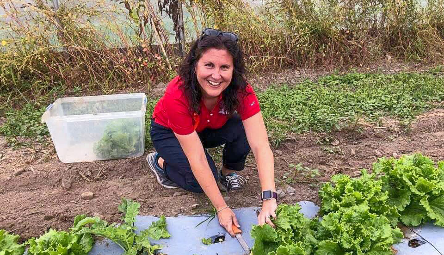 A woman smiles while gardening