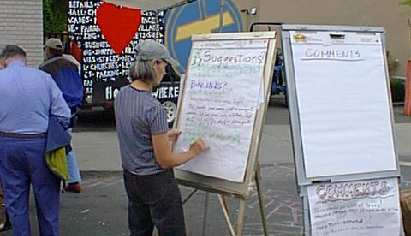 A person writes on a flipchart outdoors