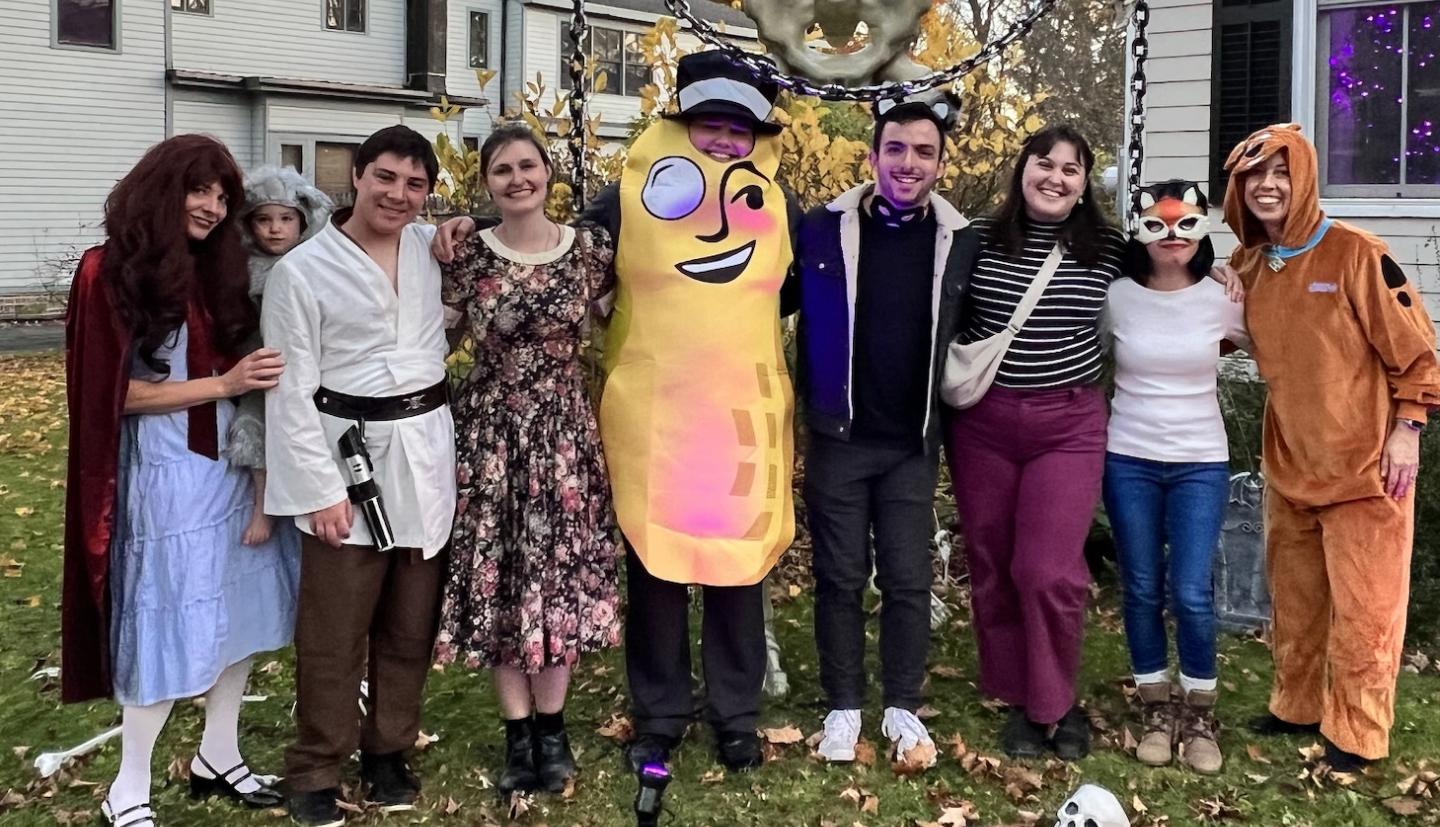 a group of people stand around in Halloween costumes