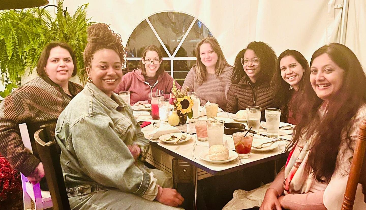 a group of people sit at a table and smile