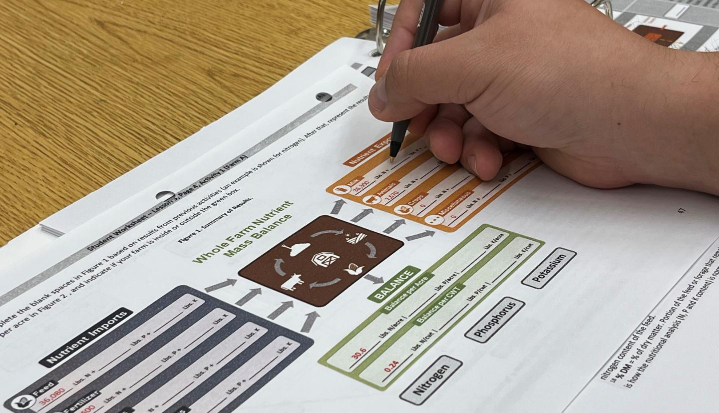 a hand holds a pen and fills out a form