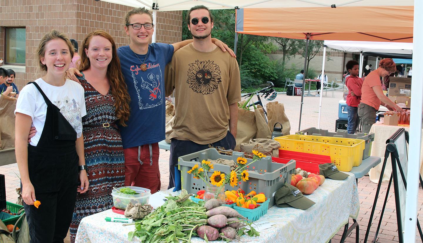 Students behind a table filled with produce