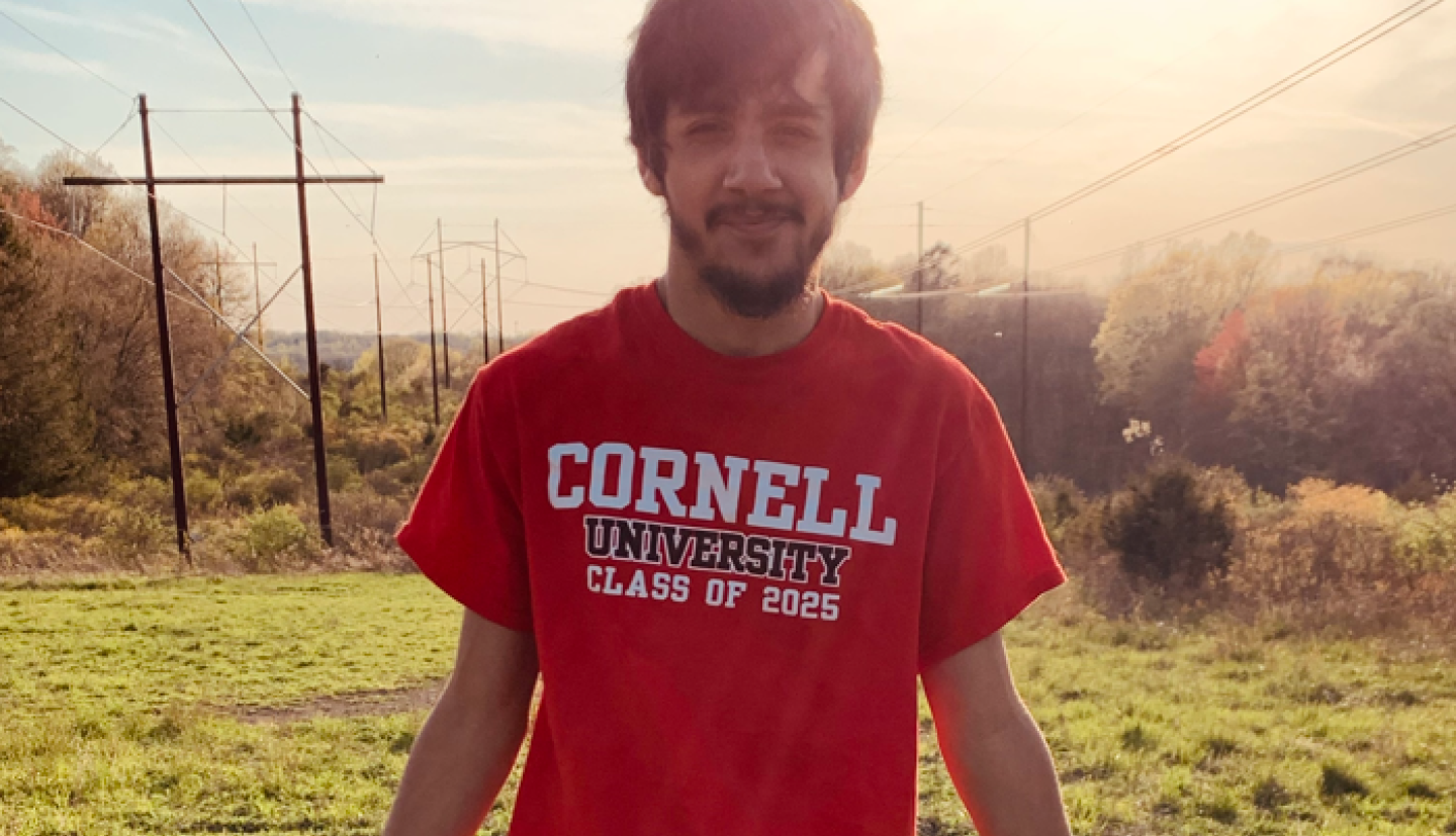 Boy sitting on a fence outside