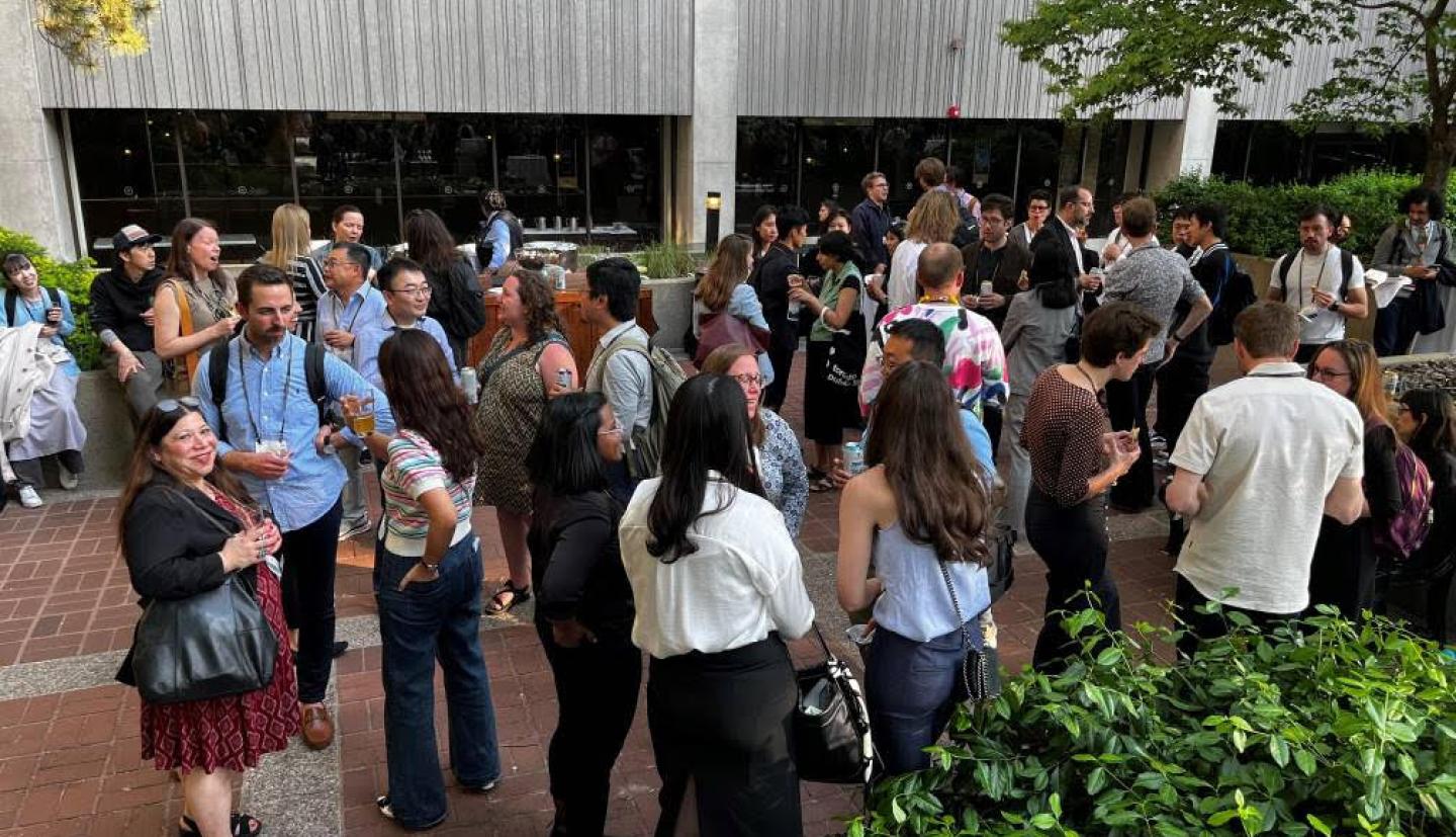 group of individuals gatherd outside enjoying drinks and hors d'oeuvres 