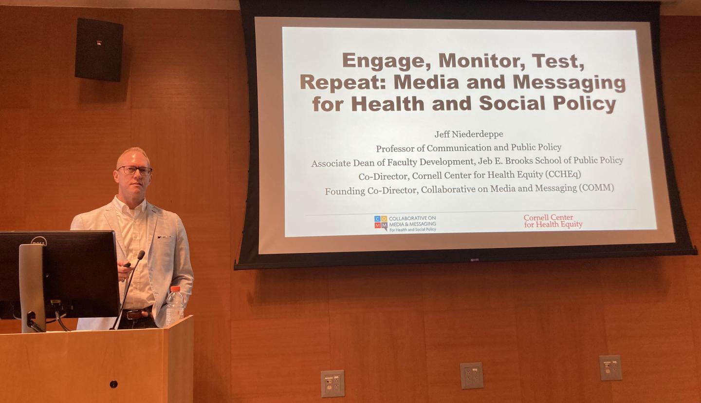 Man in front of screen giving talk