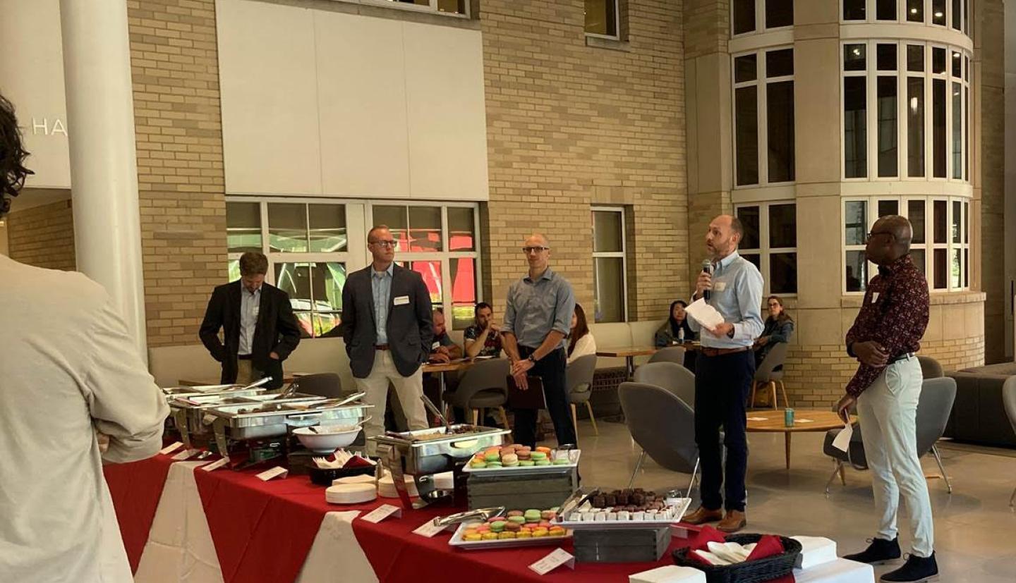 individuals stand behind buffet table