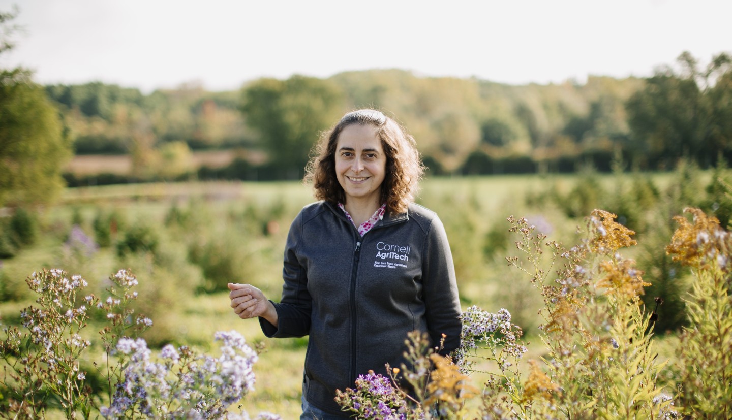 Amara Dunn-Silver standing in a field near a patch of wildflowers on a sunny day.