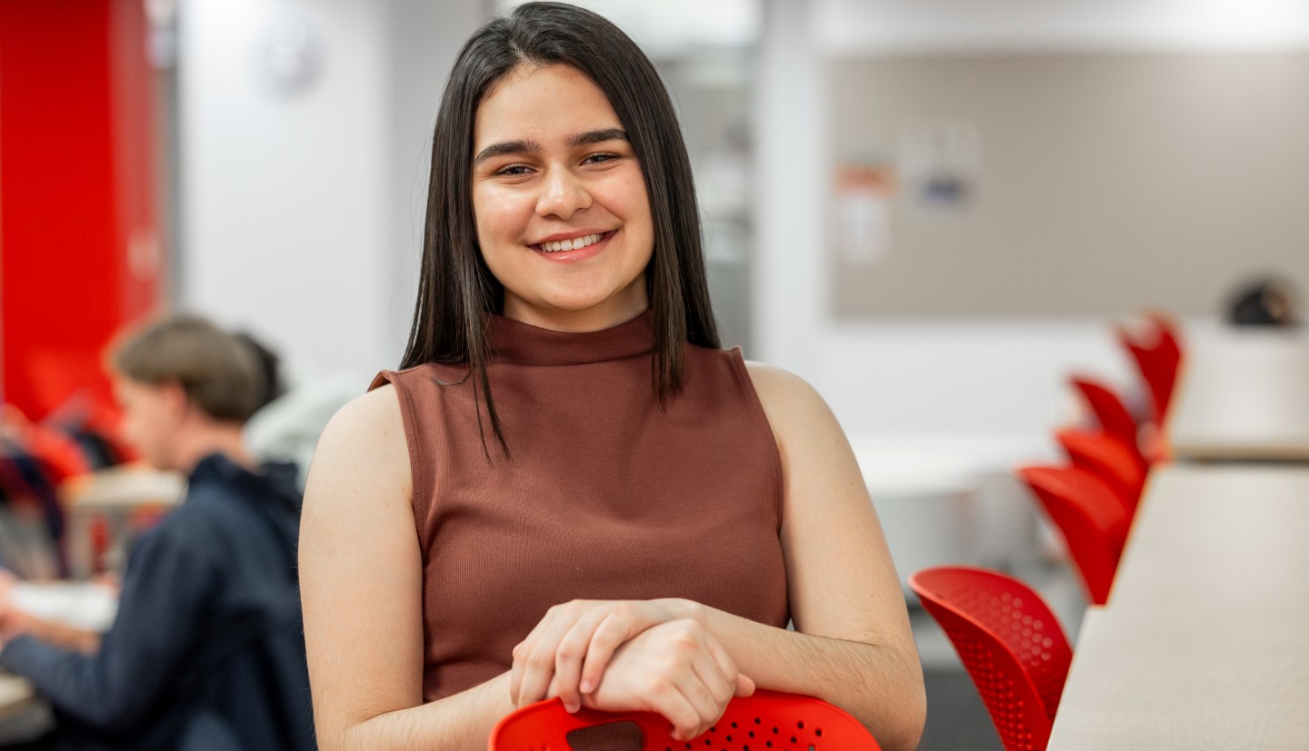 A student in a shared workspace posing 