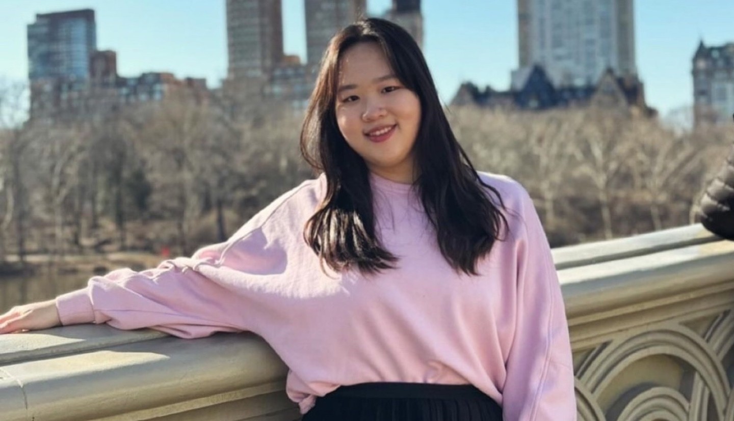 Girl standing in front of city buildings