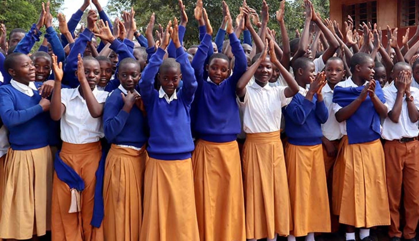 school children with hands held high