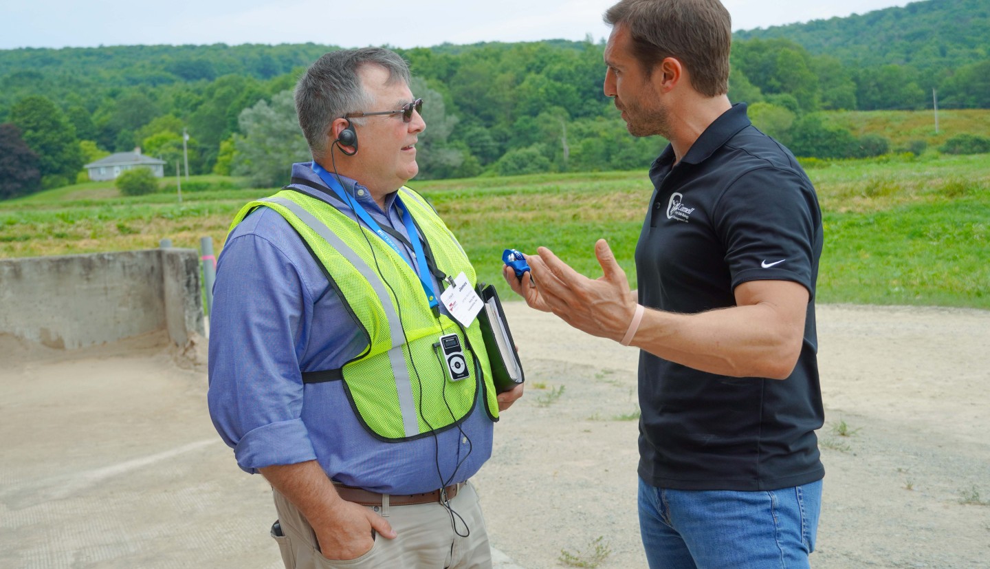 two men stand talking outside