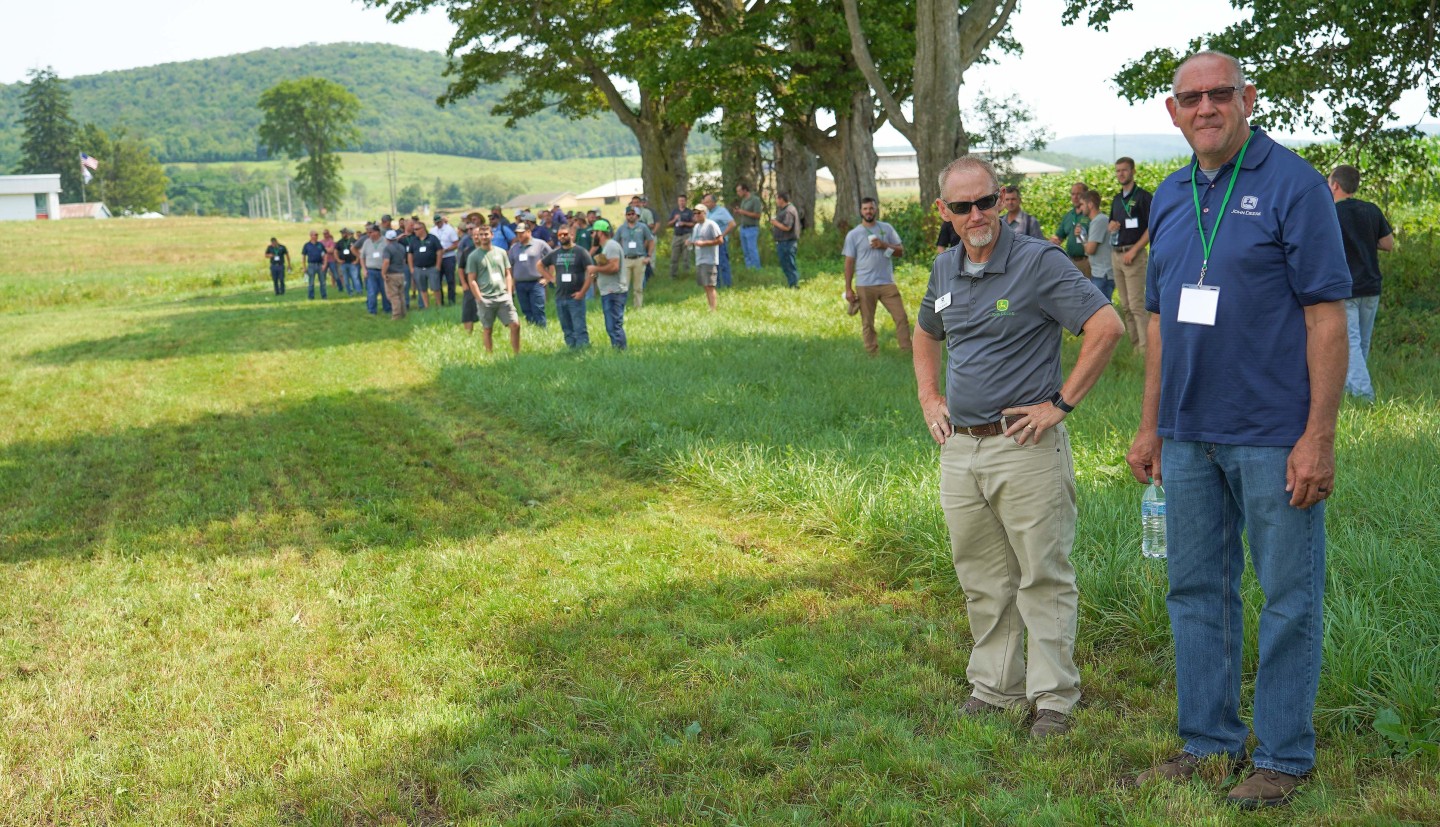 people stand in a field, looking into the distance