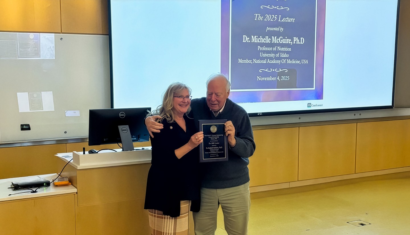 a woman holding a plaque stands next to a man