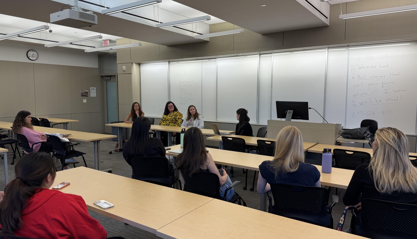 people sit at tables lined up in classroom