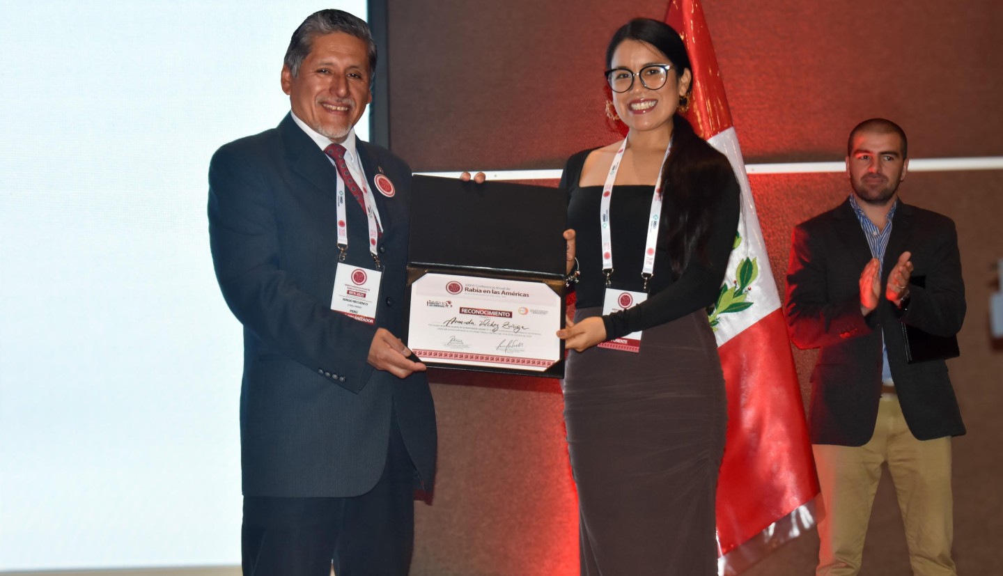 person receiving award and shaking other person's hand