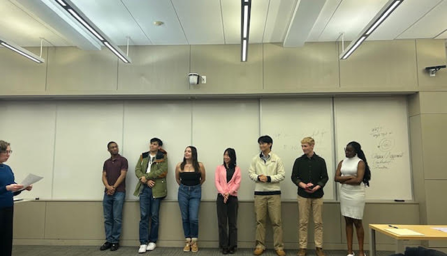 7 individuals stand in the front of a classroom